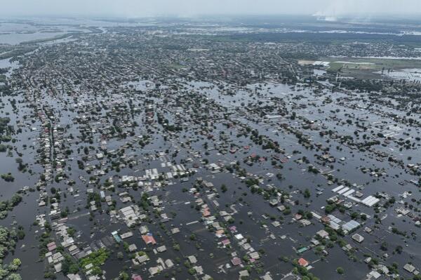 FILE - Houses are seen underwater in the flooded town of Oleshky, Ukraine, June 10, 2023. An AP investigation has found that Russian occupation authorities vastly and deliberately undercounted the dead in one of the most devastating chapters of the 22-mo<em></em>nth war in Ukraine - the flooding that followed the catastrophic explosion that destroyed the Kakhovka Dam in the southern Kherson region. (AP Photo/Evgeniy Maloletka, File)