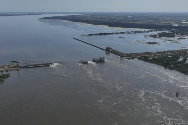 FILE - Water flows over the collapsed Kakhovka Dam in Nova Kakhovka, in Russian-occupied Ukraine, June 7, 2023. An AP investigation has found that Russian occupation authorities vastly and deliberately undercounted the dead in one of the most devastating chapters of the 22-mo<em></em>nth war in Ukraine - the flooding that followed the catastrophic explosion that destroyed the Kakhovka Dam in the southern Kherson region. (AP Photo, File)