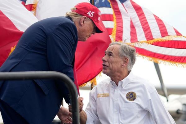 Republican presidential candidate and former President Do<em></em>nald Trump, left, shakes hands with Texas Gov. Greg Abbott, right, after he received Abbott's endorsement at the South Texas Internatio<em></em>nal Airport Sunday, Nov. 19, 2023, in Edinburg, Texas. (AP Photo/Eric Gay)