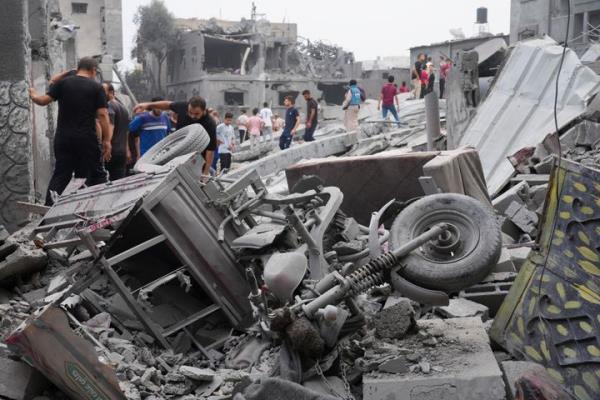 Palestinians walk a<em></em>bout buildings destroyed in the Israeli bombardment in the Nusseirat refugee camp in the Gaza Strip on Sunday, Oct. 29, 2023. (AP Photo/Hatem Moussa)