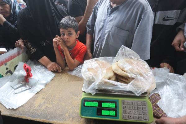 Palestinians wait to buy bread during the o<em></em>ngoing bombardment of the Gaza Strip in Rafah on Sunday, Oct. 29, 2023. (AP Photo/Hatem Ali)