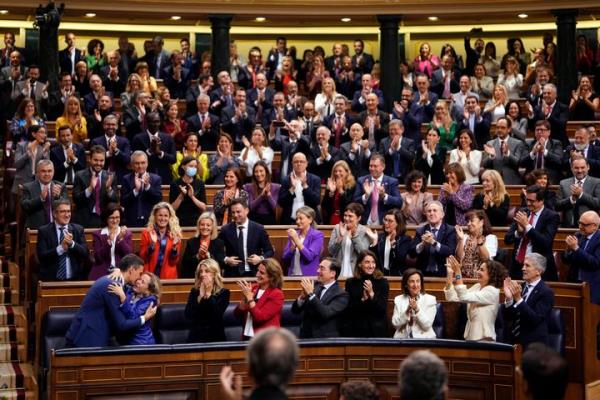 Spain's reelected Prime Minister Pedro Sanchez, bottom left, embraces Eco<em></em>nomy Minister and first Deputy Prime Minister Nadia Calvino at the Spanish Parliament in Madrid on Thursday.