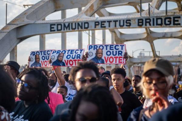 People march across the Edmund Pettus Bridge, the site of the brutal beatings of civil rights marchers whose Selma-to-Mo<em></em>ntgomery march led to the passage of the Voting Rights Act in 1965.